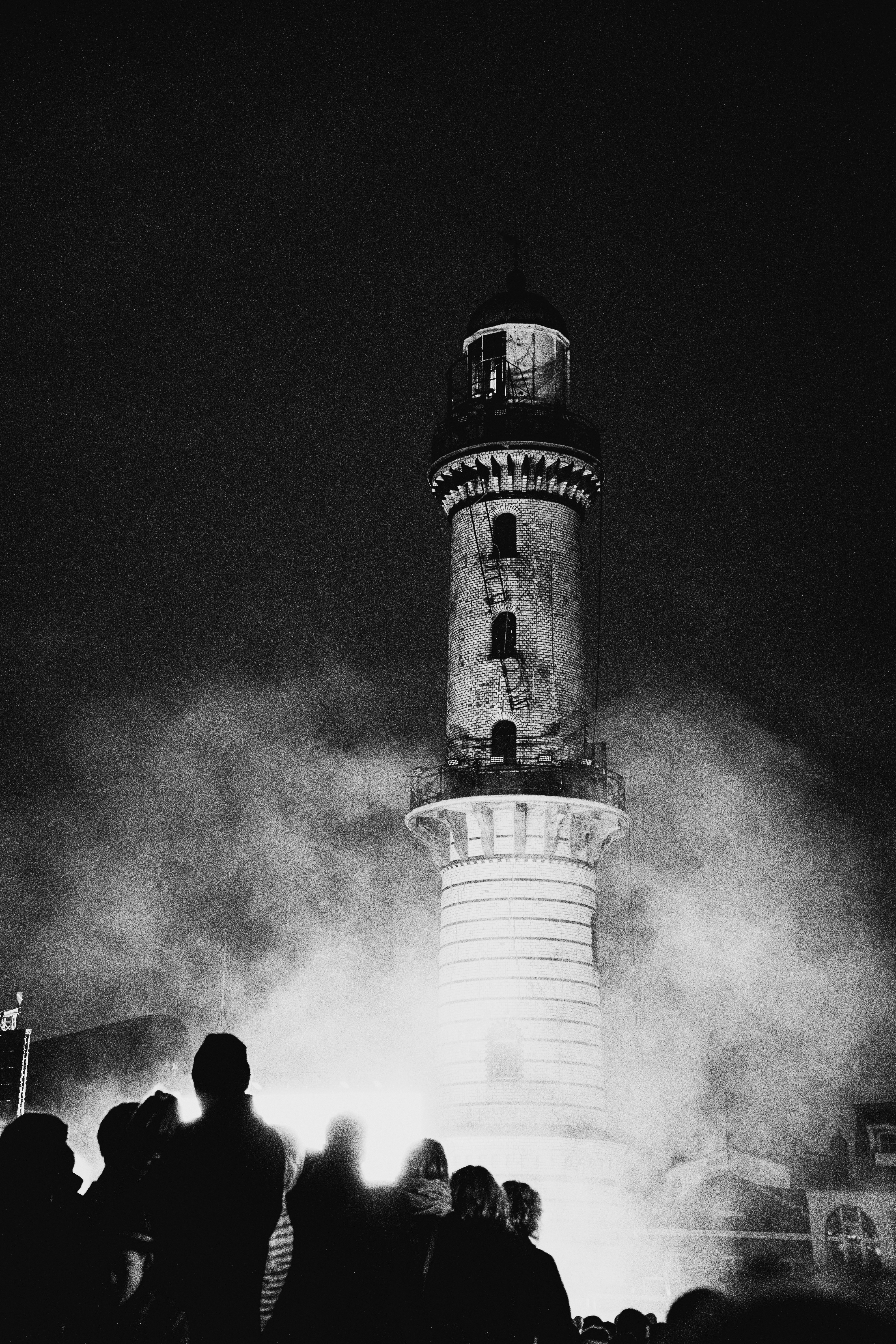 grayscale photo of lighthouse under cloudy sky